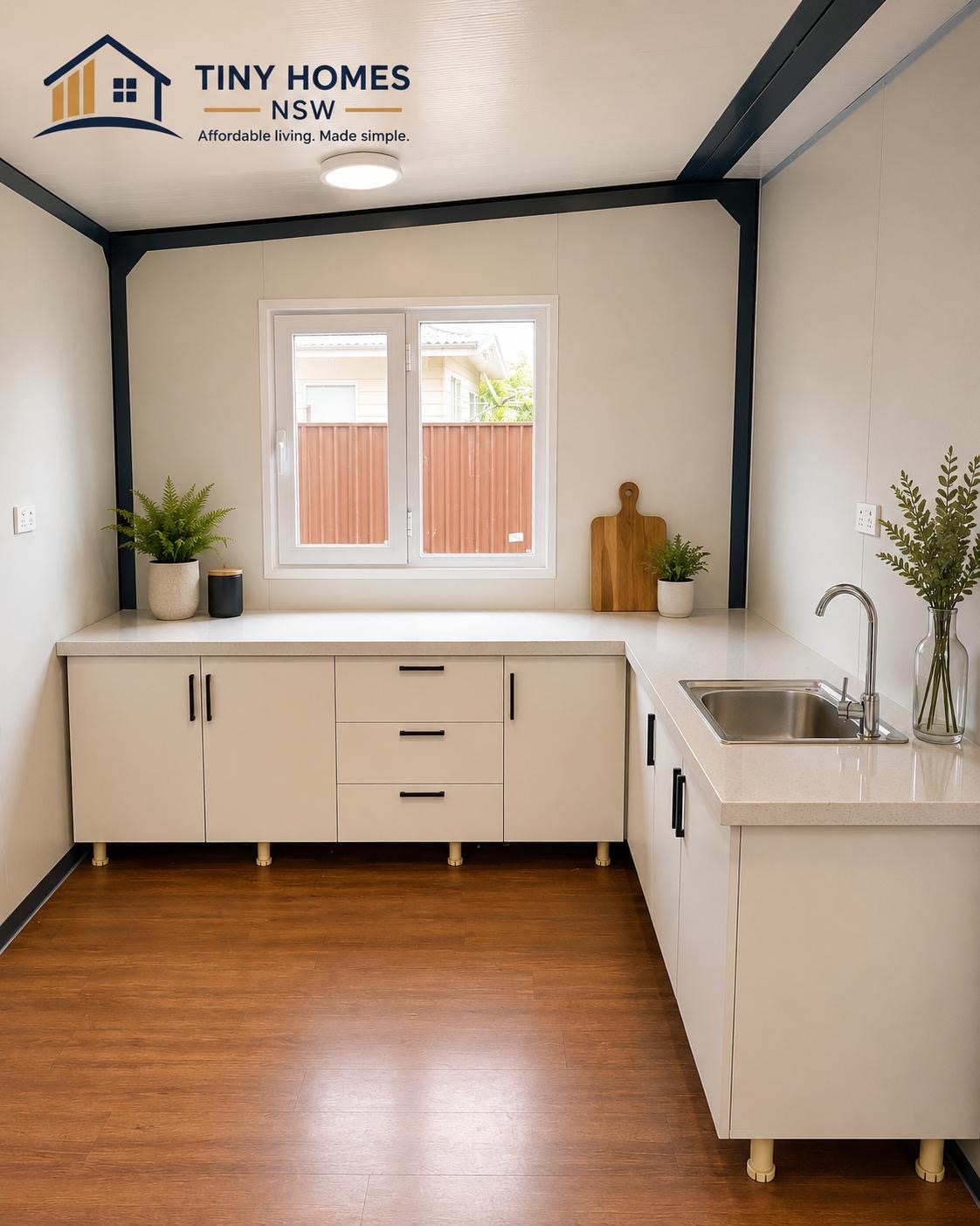 Kitchen with stone-look benchtop, sink and cabinetry inside a Tiny Homes NSW unit
